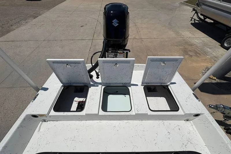 Slide: The Image of 2026 Freedom Boats 21' Commander with open storage compartments and Suzuki outboard motor. - 4