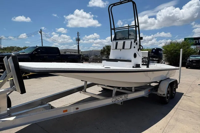 Slide: The Image of 2026 Freedom Boats 21' Commander on trailer under blue sky. - 15