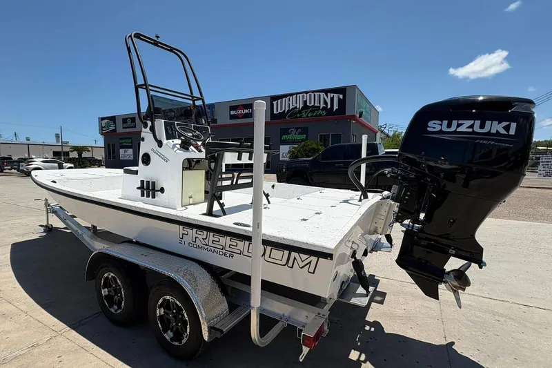 Slide: The Image of 2026 Freedom Boats 21' Commander with Suzuki engine on trailer, parked outside dealership. - 20
