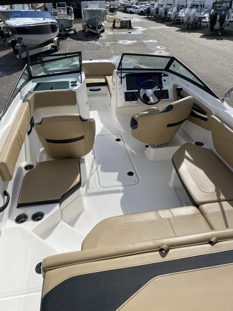 Slide: The Image of 2023 Sea Ray SPX 210 boat interior with beige seating and modern dashboard. - 8