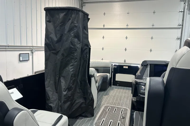Slide: The Image of Interior of 2026 Premier 230 Intrigue GT RLO pontoon boat in a garage setting. - 26