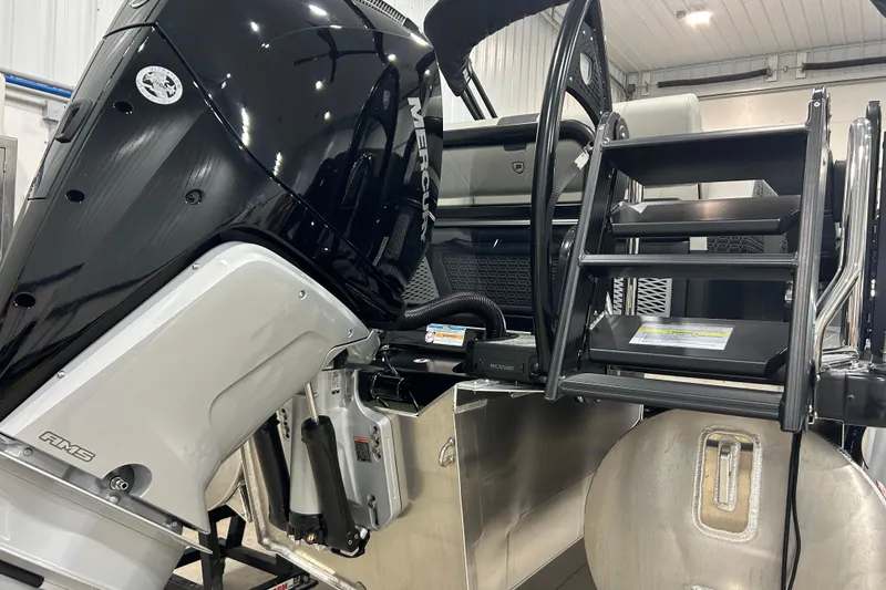 Slide: The Image of 2026 Premier 230 Intrigue GT RLO boat with Mercury engine and ladder in a garage setting. - 31