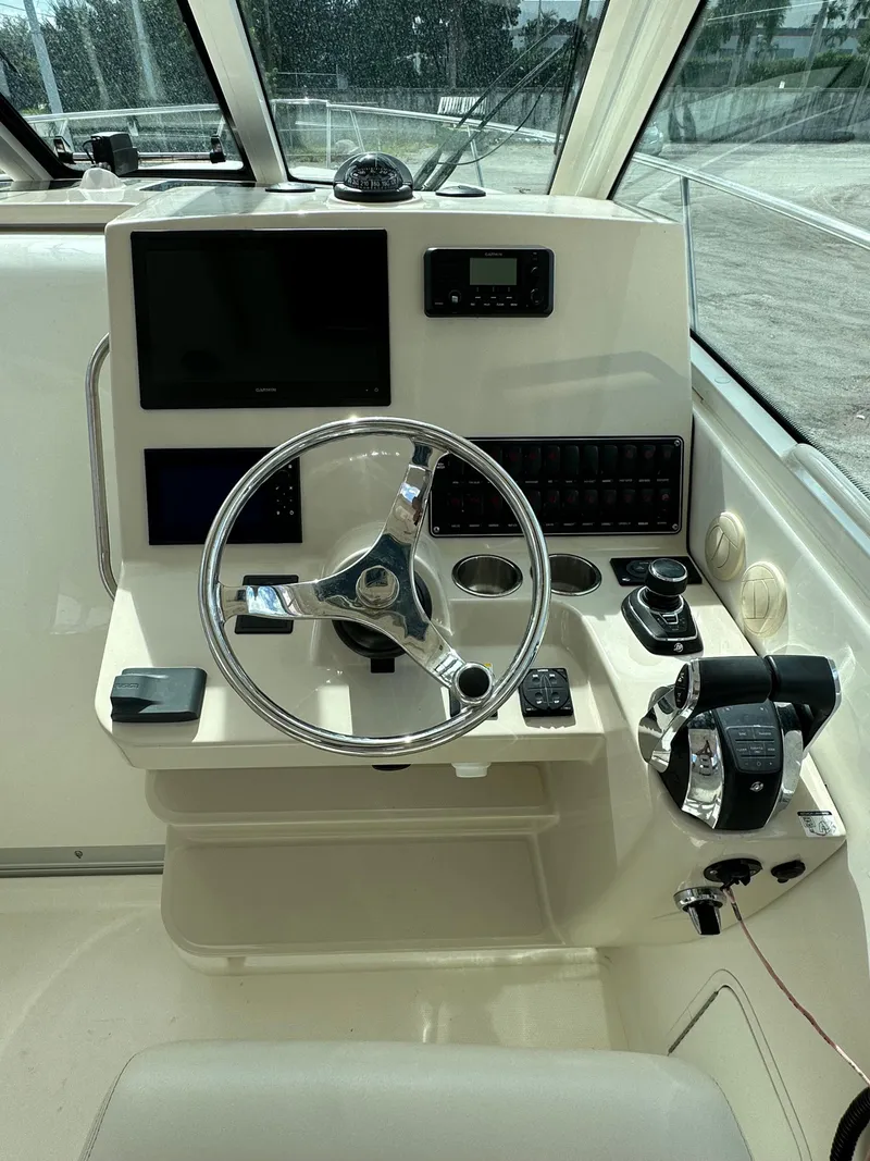 Slide: The Image of 2019 Boston Whaler 345 Conquest helm with steering wheel and control panel. - 10