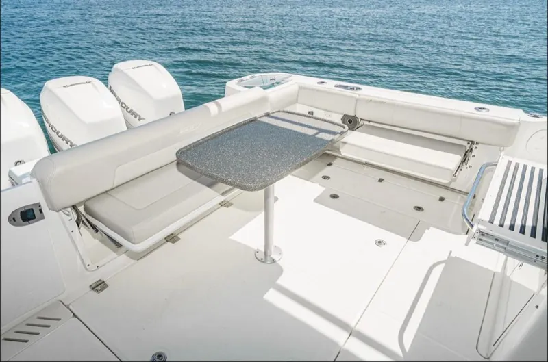 Slide: The Image of 2019 Boston Whaler 345 Conquest boat deck with seating and table, overlooking the ocean. - 11