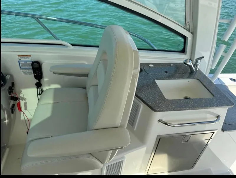 Slide: The Image of 2019 Boston Whaler 345 Conquest interior with seat and sink, overlooking water. - 15