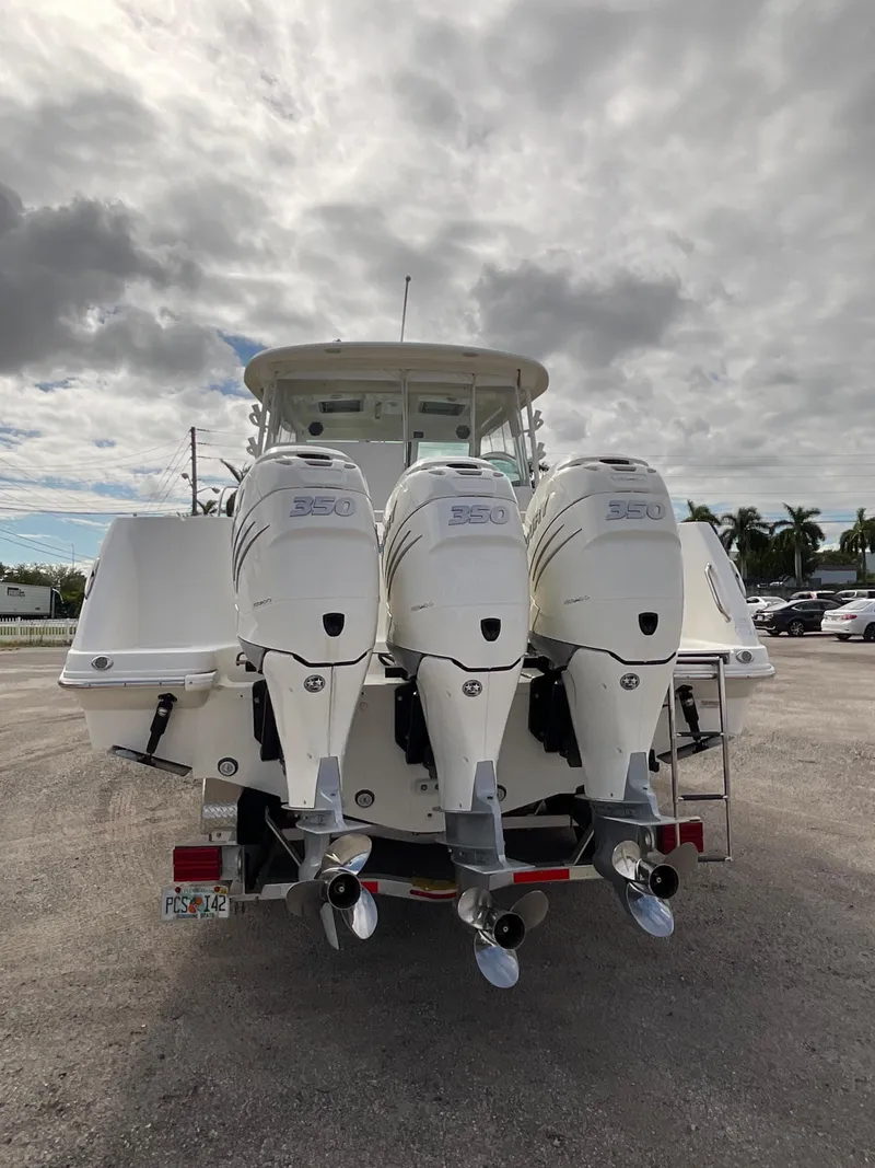 Slide: The Image of 2019 Boston Whaler 345 Conquest with triple outboard engines, parked on a cloudy day. - 4