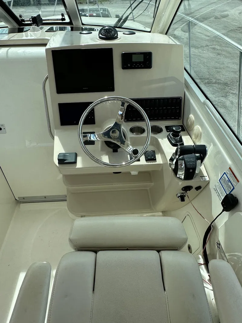 Slide: The Image of 2019 Boston Whaler 345 Conquest helm with steering wheel, controls, and navigation equipment. - 9