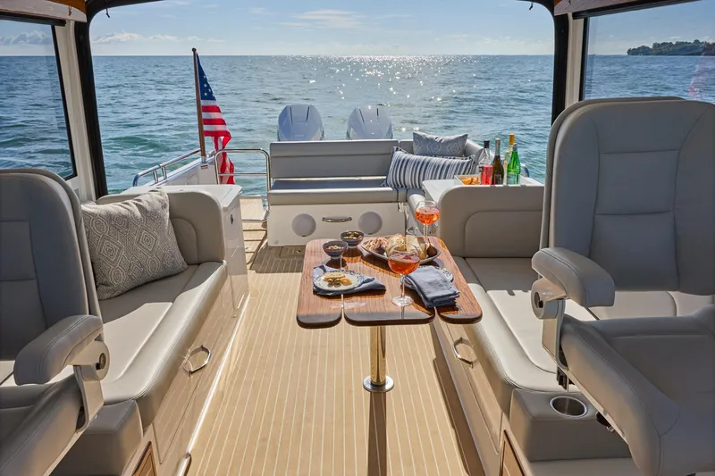 Slide: The Image of Luxurious 2026 MJM 38x yacht interior with elegant seating and dining setup on the ocean. - 5