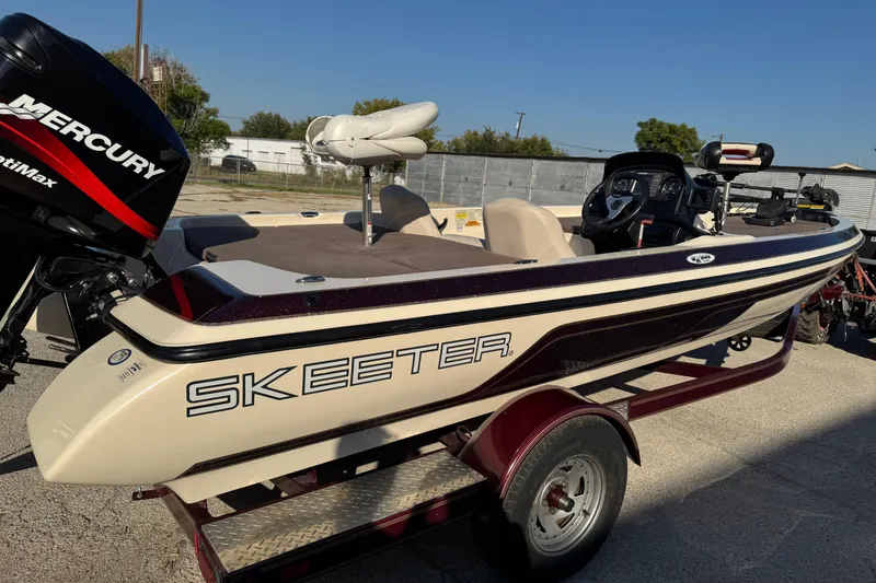 Slide: The Image of 2006 Skeeter SX200 boat with Mercury engine on trailer, parked outdoors. - 2
