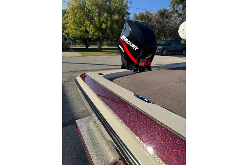Slide: The Image of 2006 Skeeter SX200 boat with Mercury engine, parked outdoors on a sunny day. - 3