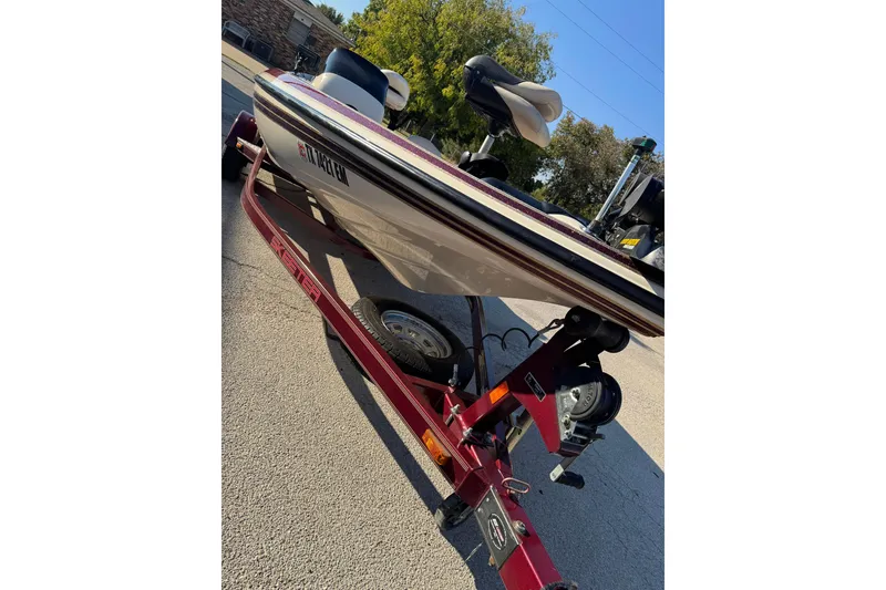 Slide: The Image of 2006 Skeeter SX200 boat on a red trailer, parked outdoors. - 4