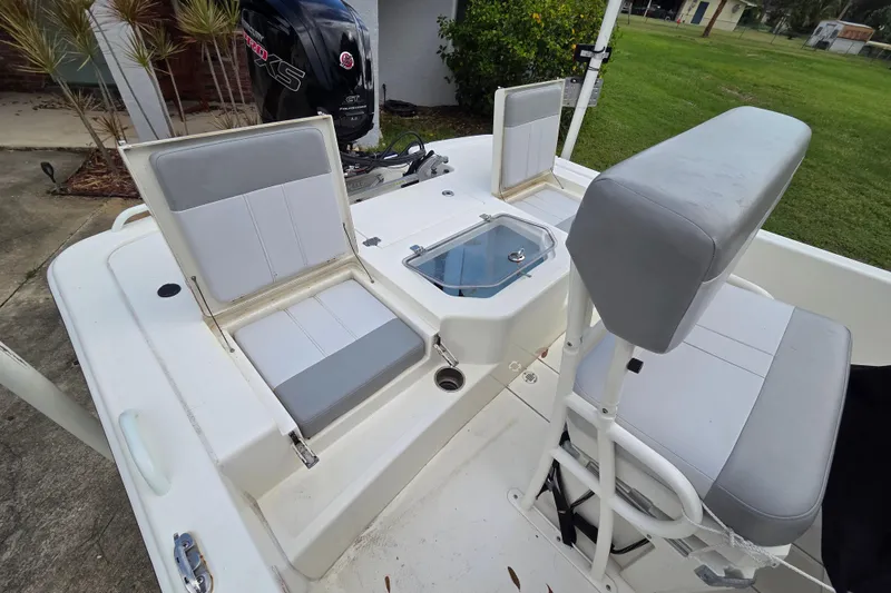 Slide: The Image of 2023 Mako Pro Skiff 19 CC boat interior with seating and storage compartments. - 15