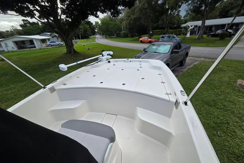 Slide: The Image of 2023 Mako Pro Skiff 19 CC boat parked in a residential driveway. - 16
