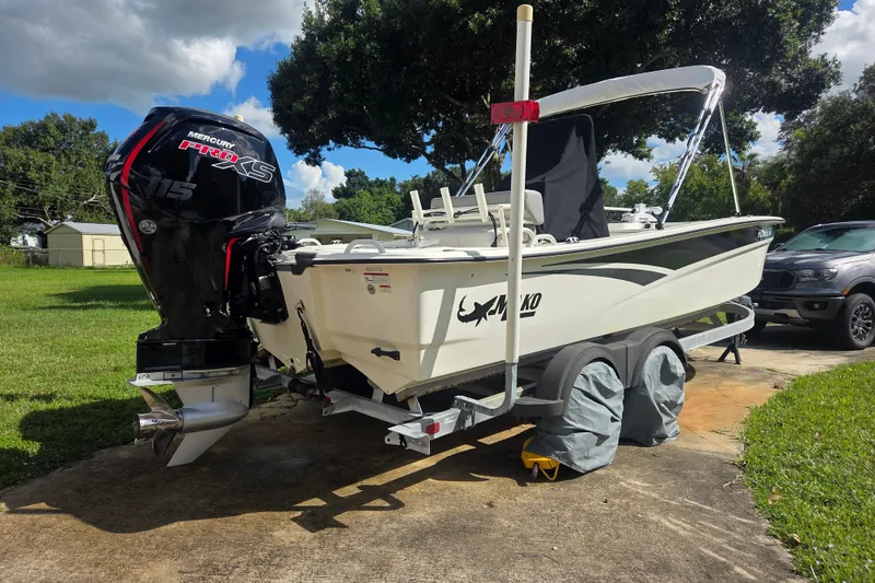 Slide: The Image of 2023 Mako Pro Skiff 19 CC boat on trailer with Mercury engine, parked outdoors. - 2