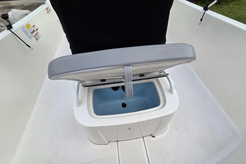 Slide: The Image of 2023 Mako Pro Skiff 19 CC boat seat with storage compartment open. - 20
