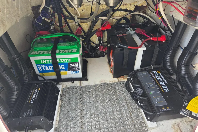 Slide: The Image of 2023 Mako Pro Skiff 19 CC boat battery compartment with Interstate marine batteries and chargers. - 29