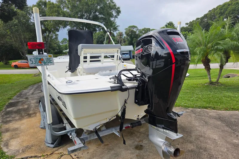 Slide: The Image of 2023 Mako Pro Skiff 19 CC with Mercury 115 Pro XS engine, parked on a trailer. - 3