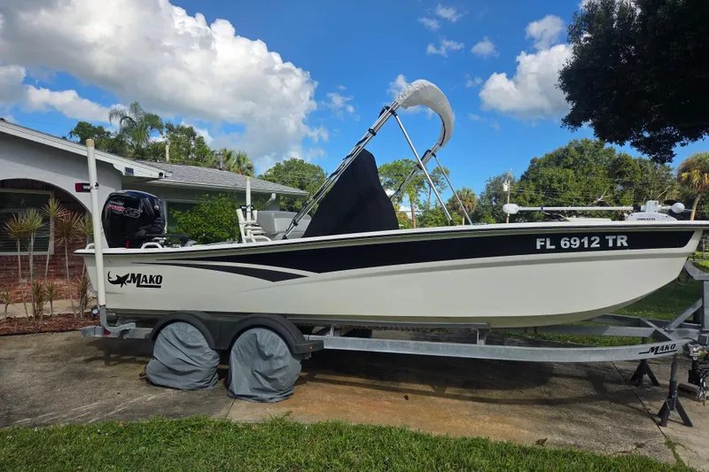 Slide: The Image of 2023 Mako Pro Skiff 19 CC boat on trailer, parked in residential driveway. - 4