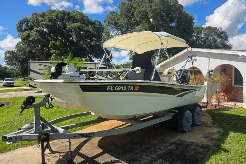 Slide: The Image of 2023 Mako Pro Skiff 19 CC boat on trailer, parked in residential driveway. - 6