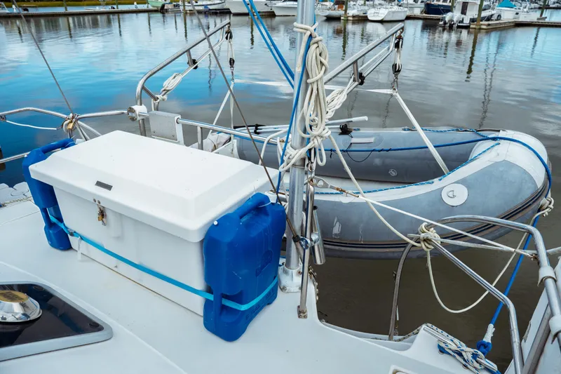 Slide: The Image of 1994 Catalina 38 CC sailboat deck with dinghy and storage box at marina. - 13