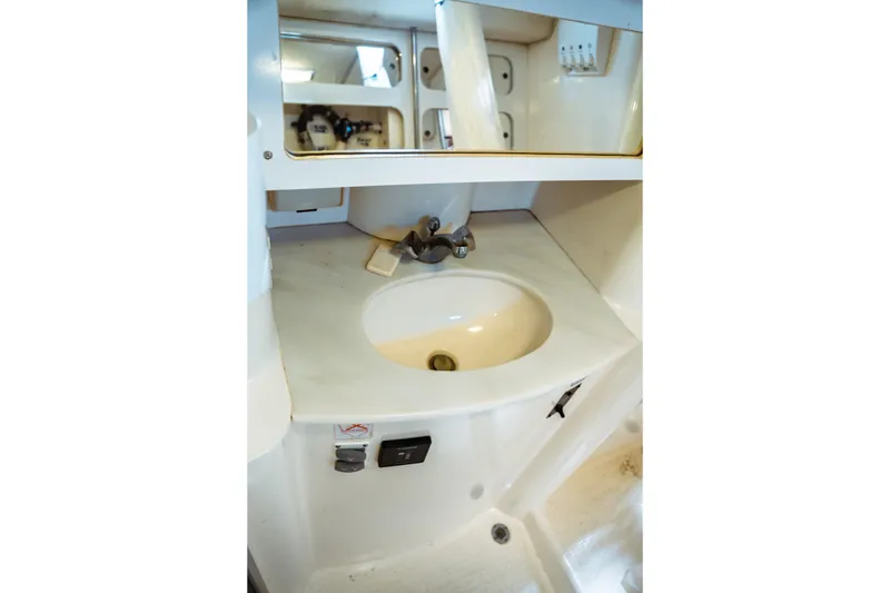 Slide: The Image of 1994 Catalina 38 CC yacht bathroom sink with mirror and storage. - 23