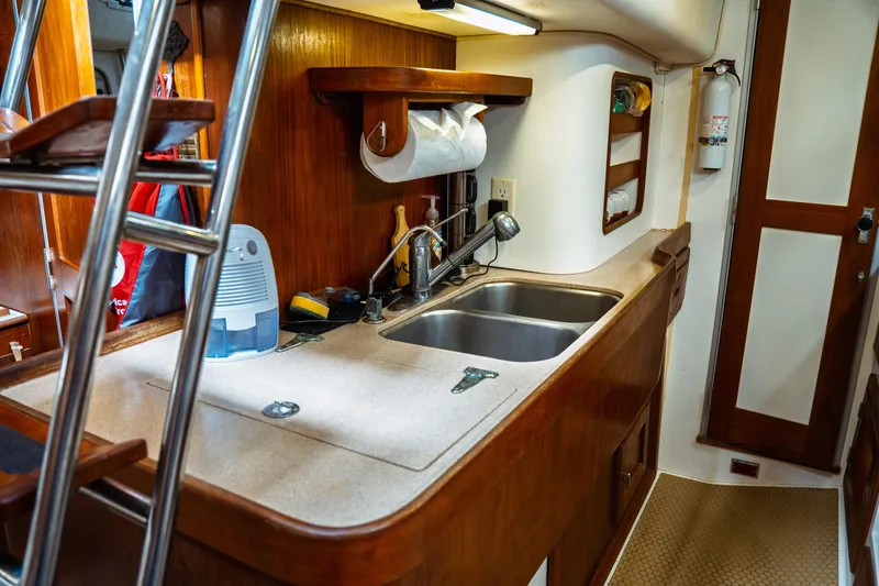 Slide: The Image of 1994 Catalina 38 CC yacht interior with wooden cabinetry and compact kitchen area. - 30
