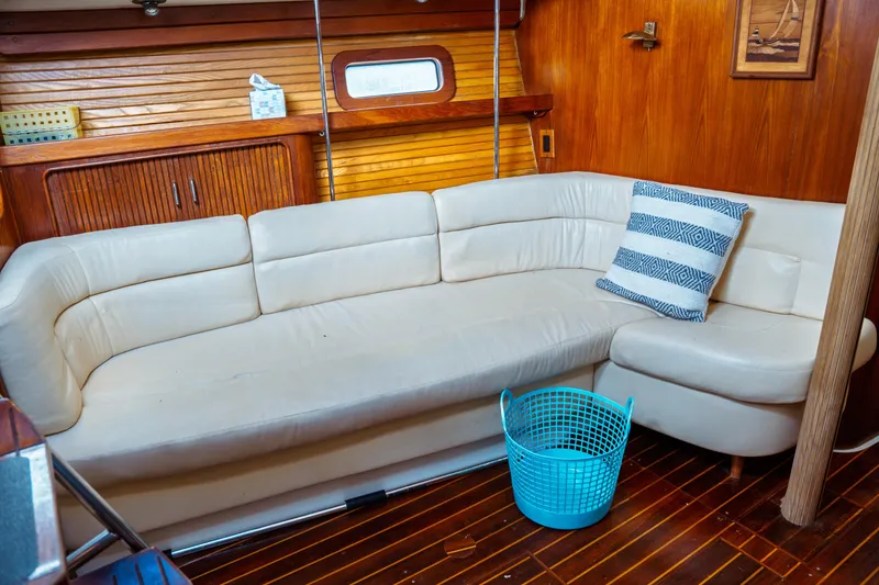 Slide: The Image of Interior of 1994 Catalina 38 CC yacht with white sofa and blue basket. - 32