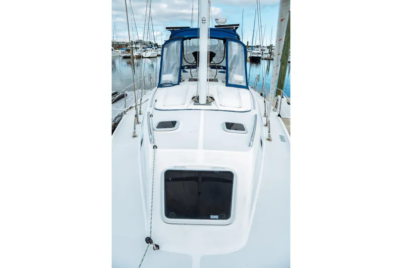 Slide: The Image of 1994 Catalina 38 CC sailboat deck view at marina, featuring blue canopy and clear sky. - 5