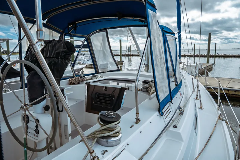 Slide: The Image of 1994 Catalina 38 CC sailboat cockpit with blue canopy, docked at marina. - 6