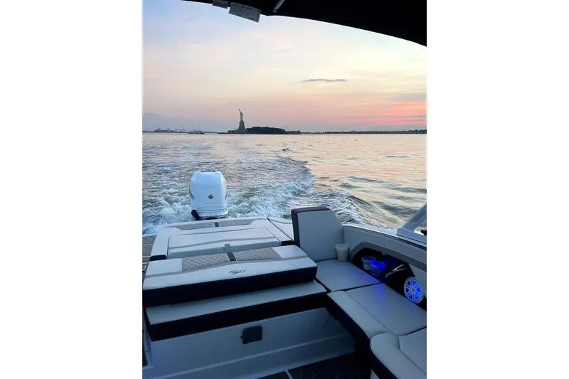 Slide: The Image of 2023 Monterey 275SS Super Sport boat cruising near the Statue of Liberty at sunset. - 4