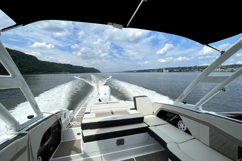 Slide: The Image of 2023 Monterey 275SS Super Sport cruising on a scenic waterway under a clear sky. - 5