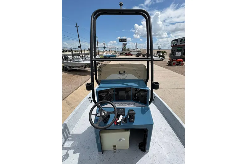 Slide: The Image of 2026 Freedom Boats 21' Commander console with steering wheel and controls, outdoor setting. - 10
