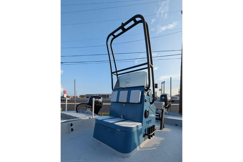 Slide: The Image of 2026 Freedom Boats 21' Commander, blue console, docked under clear sky. - 3