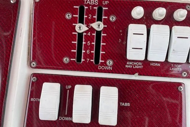 Slide: The Image of Control panel of a 2001 Fountain 38 Center Console boat with switches and trim tabs. - 13