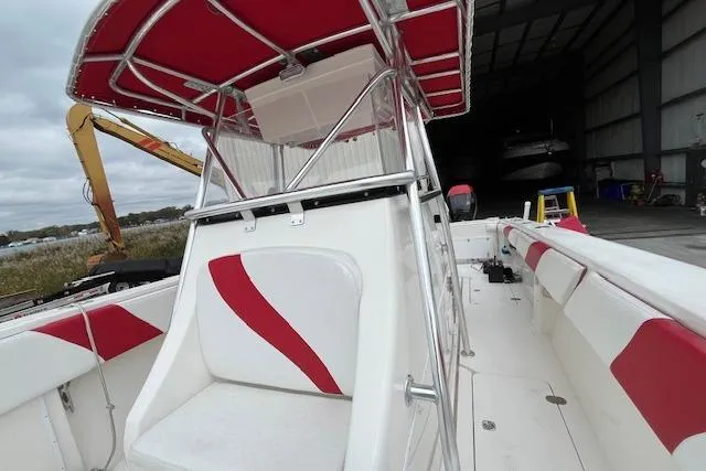 Slide: The Image of 2001 Fountain 38 Center Console boat with red and white seating, docked in a marina. - 23