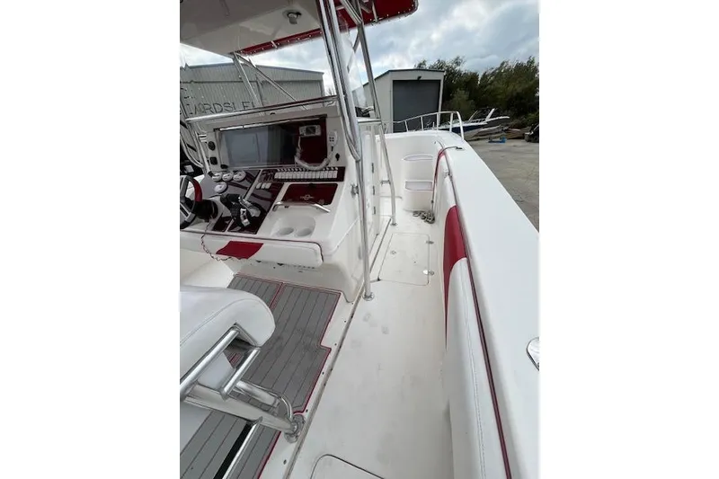 Slide: The Image of 2001 Fountain 38 Center Console boat interior with red and white seating and control panel. - 24