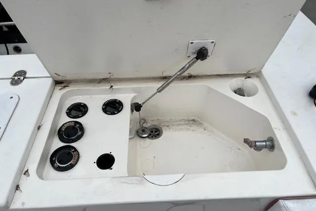 Slide: The Image of 2001 Fountain 38 Center Console boat compartment with open hatch and control dials. - 28