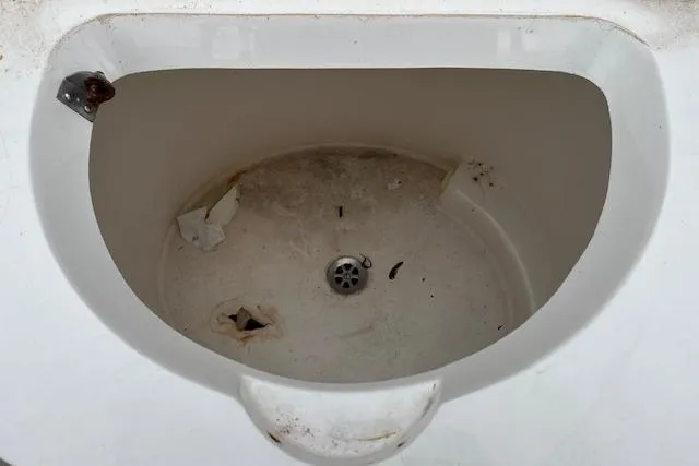 Slide: The Image of 2001 Fountain 38 Center Console livewell, showing interior with drain and debris. - 30