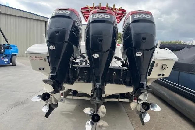 Slide: The Image of 2001 Fountain 38 Center Console boat in storage, featuring red canopy and fishing rod holders. - 4