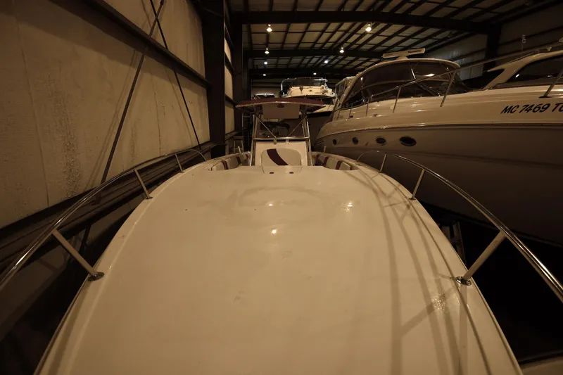 Slide: The Image of 2001 Fountain 38 Center Console boat in indoor storage, surrounded by other vessels. - 41