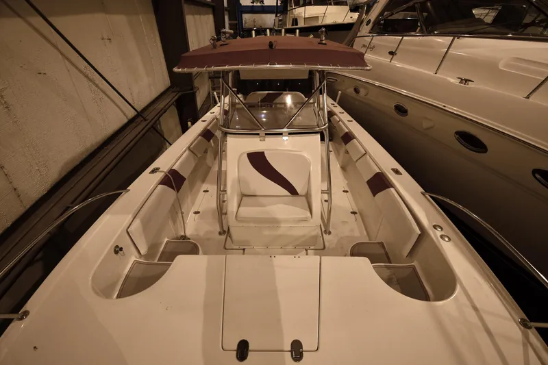 Slide: The Image of 2001 Fountain 38 Center Console boat with maroon accents, docked indoors. - 42