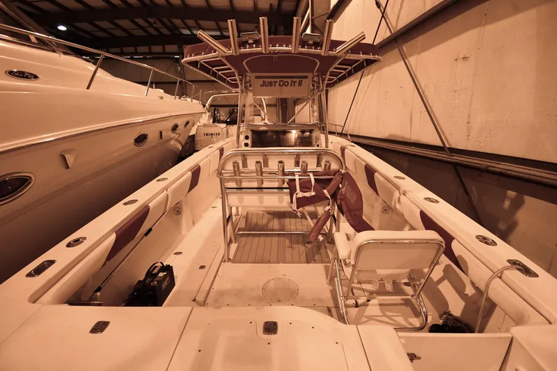 Slide: The Image of 2001 Fountain 38 Center Console boat in indoor storage, featuring spacious seating and fishing rod holders. - 43