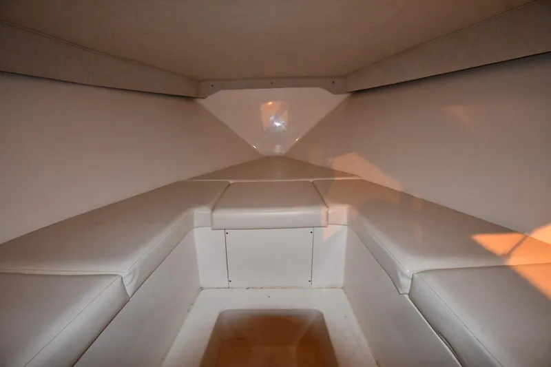 Slide: The Image of Interior cabin of a 2001 Fountain 38 Center Console boat, featuring white cushioned seating. - 58