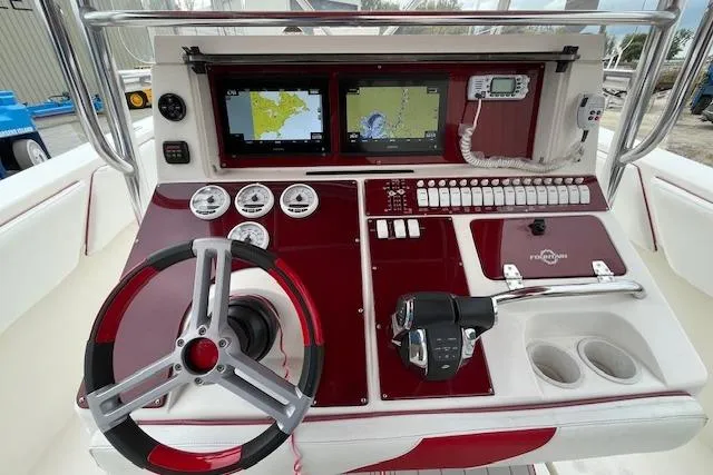 Slide: The Image of 2001 Fountain 38 Center Console boat dashboard with navigation screens and controls. - 6