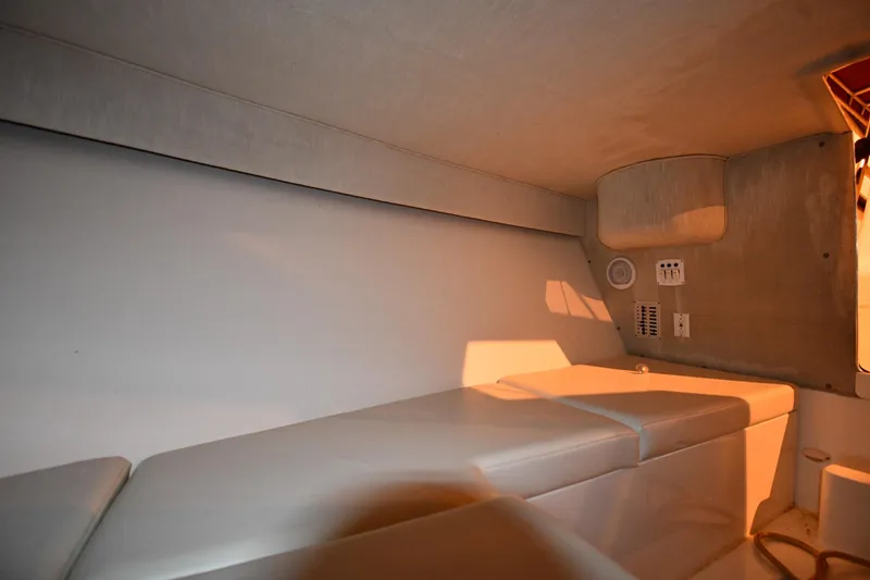 Slide: The Image of Interior cabin of 2001 Fountain 38 Center Console boat, featuring cushioned seating and control panel. - 62