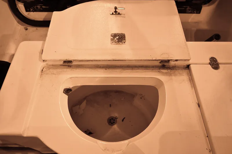 Slide: The Image of 2001 Fountain 38 Center Console boat sink with closed lid, showing wear and dirt. - 65