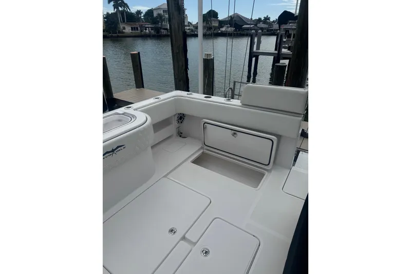 Slide: The Image of 2024 Invincible 39 Open Fisherman boat interior at dockside, showcasing storage and seating. - 12
