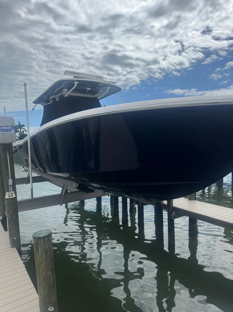 Slide: The Image of 2024 Invincible 39 Open Fisherman boat docked under cloudy sky. - 16