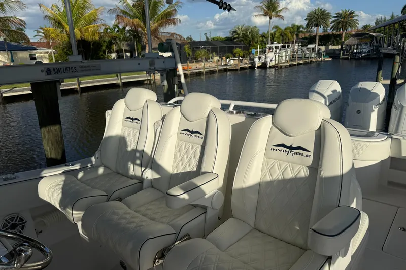 Slide: The Image of 2024 Invincible 39 Open Fisherman boat with luxurious white seating and scenic waterfront view. - 19