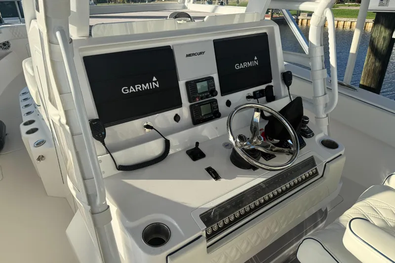 Slide: The Image of 2024 Invincible 39 Open Fisherman helm with Garmin displays and Mercury controls. - 21